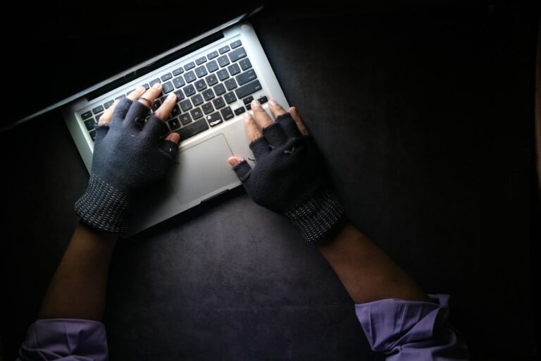 Bug Bounty como começar - pessoa digitando no laptop com luvas